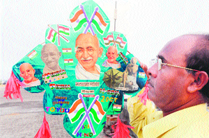 Tributes to father of the nation: Kite artist Jagmohan Kanijia pays tribute to Mahatma Gandhi showing miniature kite bearing his image prepared by him in Amritsar on Tuesday.
