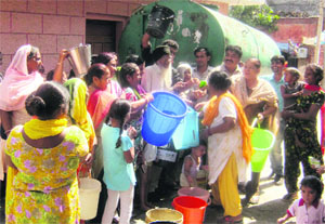 Residents of Krishana Nagar stand in a queue near a tanker for getting water in Jalandhar.
