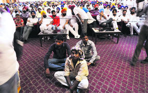 Migrants sit in front of the stage to listen to Akali leaders during the lalkar rally in Ludhiana. 