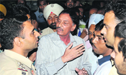 Kotwali SHO Karamjit Singh pacifies people at a fuel station in Bathinda on Wednesday. Tribune photo: Pawan Sharma