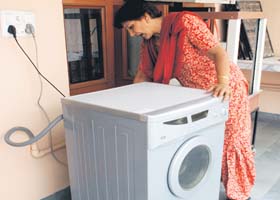A woman shows out-of-order washing machine in Sector 2, Panchkula, on Wednesday
