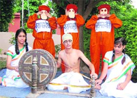 A student dressed as Mahatma Gandhi spins a wheel at Ashmah International School in Mohali
