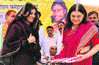 Adampur MLA Renuka Bishnoi (left) presents a bouquet to Maneka Gandhi at Badopal in Fatehabad on Wednesday