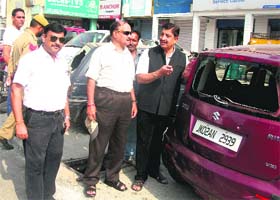 A local leader shows damaged vehicles at the New Plot area in Jammu on Wednesday