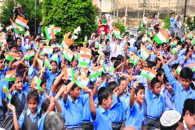 Schoolchildren holding Tricolour participate in the Gandhi Jayanti celebrations at the Mubark Mandi Complex in Jammu on Wednesday