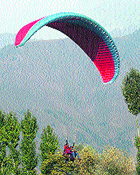 Paragagliders take a joy ride during an event organised by the tourism department on the outskirts of Srinagar on Wednesday