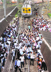 Farmers participating in the Apang Shetkari Andolan stop a train during a protest in Mumbai on Wednesday