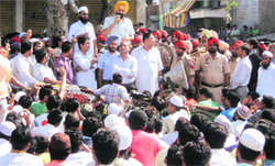Sangrur SSP (in orange turban) Mandeep Singh Sidhu pacifies protesters at Jarag Chowk in Malerkotla on Wednesday. A Tribune photograph