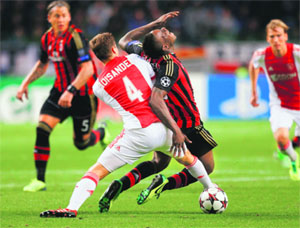 AC Milan's Mario Balotelli falls as he is challenged by Ajax Amsterdam's Niklas Moisander during their Champions League match at the Amsterdam Arena stadium on Tuesday.