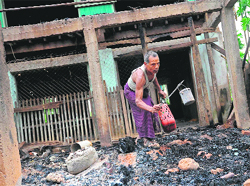 A man salvages items from a burnt mosque at Thabyu Chi village in Myanmar on Wednesday. AFP