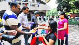 Students distribute sweets at the Student Centre of Panjab University on Thursday.