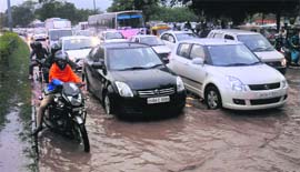 Vehicles pass through a water-logged road near the Sector 29 roundabout in Chandigarh on Thursday.
