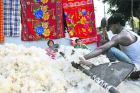 A vendor threshes cotton to make quilts in Karnal.