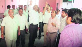Devender Singh, CMD, UHBVN, (third from left) inquires about the functioning of the display board on a computerised cash counter at the nigam office in Indira Colony, Sonepat.