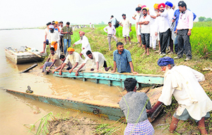 Villagers pull out the ill-fated boat on the banks of the Beas at Kabirpur village on Thursday. Tribune photo: Malkiat Singh 