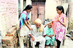 Sisters Rekha and Raman with their grandparents Gurdev Singh and Kartar Kaur, at their ramshackle house in village Chuhrwali in Jalandhar