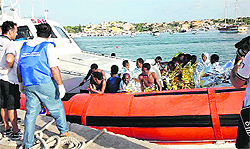 Rescued migrants arrive at Lampedusa harbour on Thursday