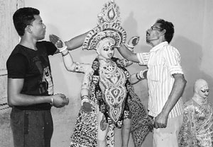 Sculptors from West Bengal give final touches to an idol at Tara Devi Temple in Kangra on Friday. 