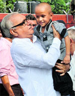 Chief Minister Bhupinder Singh Hooda lifts wonder kid Kautilya Pandit after handing over a fixed deposit certificate for Rs 10 lakh in Chandigarh on Friday.