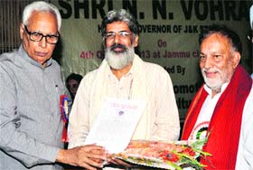 Governor NN Vohra presents an award to Ravinder Jamwal, reputed sculptor, at a function in Jammu on Friday.