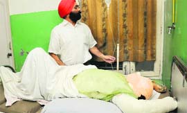 A plastic surgeon attends to acid attack victim Jatinder Kaur at a private hospital in Jalandhar on Friday.