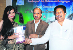 Minister for Housing, Horticulture and Culture, Raman Bhalla, gives away the best female actress award to Neelam in Srinagar on Friday.