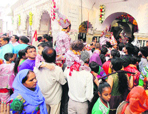 Devotees wait for their turn to pay obeisance at the Langoor Mela at Bada Hanuman Mandir in the Durgiana Temple complex in Amritsar on Saturday. 