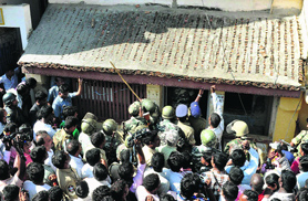 Armed forces try to enter the house of the two terror suspects during an operation at Puttur in Chittoor district.