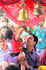 A child tries to ring a bell at the Kali Temple in Jammu on Saturday. 
