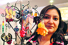 An artist with her quilled paper jewellery at the exhibition