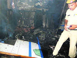 A policeman inspects the damage caused to the SBI branch on Karnal Road in Kaithal Town on Sunday evening.