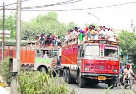 THROWING NORMS TO THE WIND: Overloaded trucks ply on a road in Amritsar on Monday