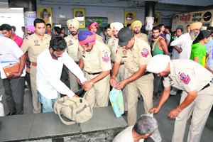 Surprise check: As festive season sets in, policemen search the baggages of passengers to avoid any untoward incident at the bus stand in Bathinda on Monday.