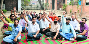 Employees working under the National Rural Health Mission protest outside the Civil Surgeons office in Ludhiana on Monday.