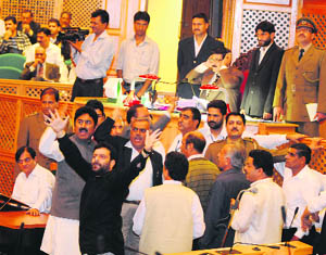 Opposition PDP MLAs shout slogans in front of the Speaker after trooping into the Well of the House in Srinagar on Tuesday. 