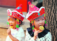 Young Chinese girls enjoy lollipops during their visit to Tiananmen Square in Beijing on Tuesday.