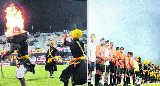 A gatka team of Nihangs performs an act of daredevilry during the opening ceremony of the event in Jalandhar on Wednesday; and (right) Pollution caused by crackers seems to irritate players at Burlton Park on the opening ceremony of the 30th Surjit Hockey Tournament.