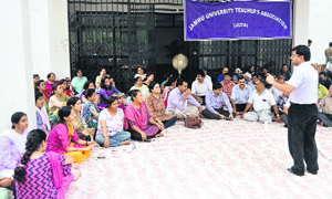 Members of the Jammu University Teachers Association stage a dharna outside the Vice-Chancellors office on the university campus in Jammu on Wednesday.