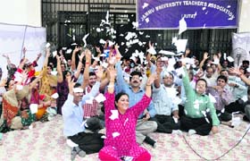 Jammu University teachers tear copies of UGC regulations amended in 2013 on Thursday