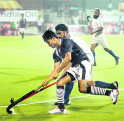 Players of PSPCL (white) and Indian Navy (black) in action during the final of the 30th Indian Oil Surjit Hockey Tournament in Jalandhar on Thursday. 