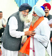 Chief Minister Parkash Singh Badal honours a villager who went to jail several times during Akali Dal protests, at a village in Muktsar on Thursday. 