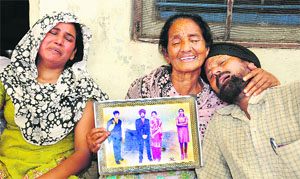 Jagir Singh (right) who lost 11 members of his family with grieving relatives in Kapurthala on Thursday. 