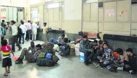 Passengers wait at the ticket reservation centre at the railway station in Amritsar on Friday.