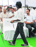 A student in school uniform serves water to visitors during an auction of commercial sites by HUDA at Sector 6, Panchkula, on Friday. Tribune Photo: Nitin Mittal