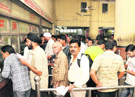 Residents stand in queue for Tatkal quota tickets at the railway station in Jalandhar on Friday. 