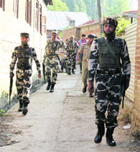 Police and CRPF personnel cordon off Koil village in Pulwama district after militants attacked a police post in the village on Friday