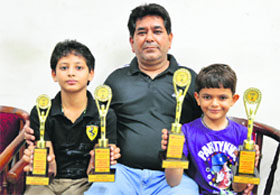 Lakshaya Sharma (right) and Aman Jain, with their coach Mangat Lal Sharma show their trophies in Ludhiana on Friday.