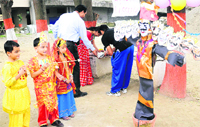 Tiny tots try to hit Ravans effigy during the Ravan Vadh programme at Manav Bharti India International in Dehradun on Saturday. Tribune photo: Vinod Pundhir