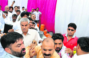 Congress worker Virender Neetu (second from left) in action at the birthday function of Congress MP Arvind Sharma in Karnal on Saturday. 