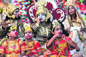The child artistes depicting Lord Rama, Sita, Lakshman and Hanuman eat choclates during the Dasehra procession in Dehradun on Sunday.